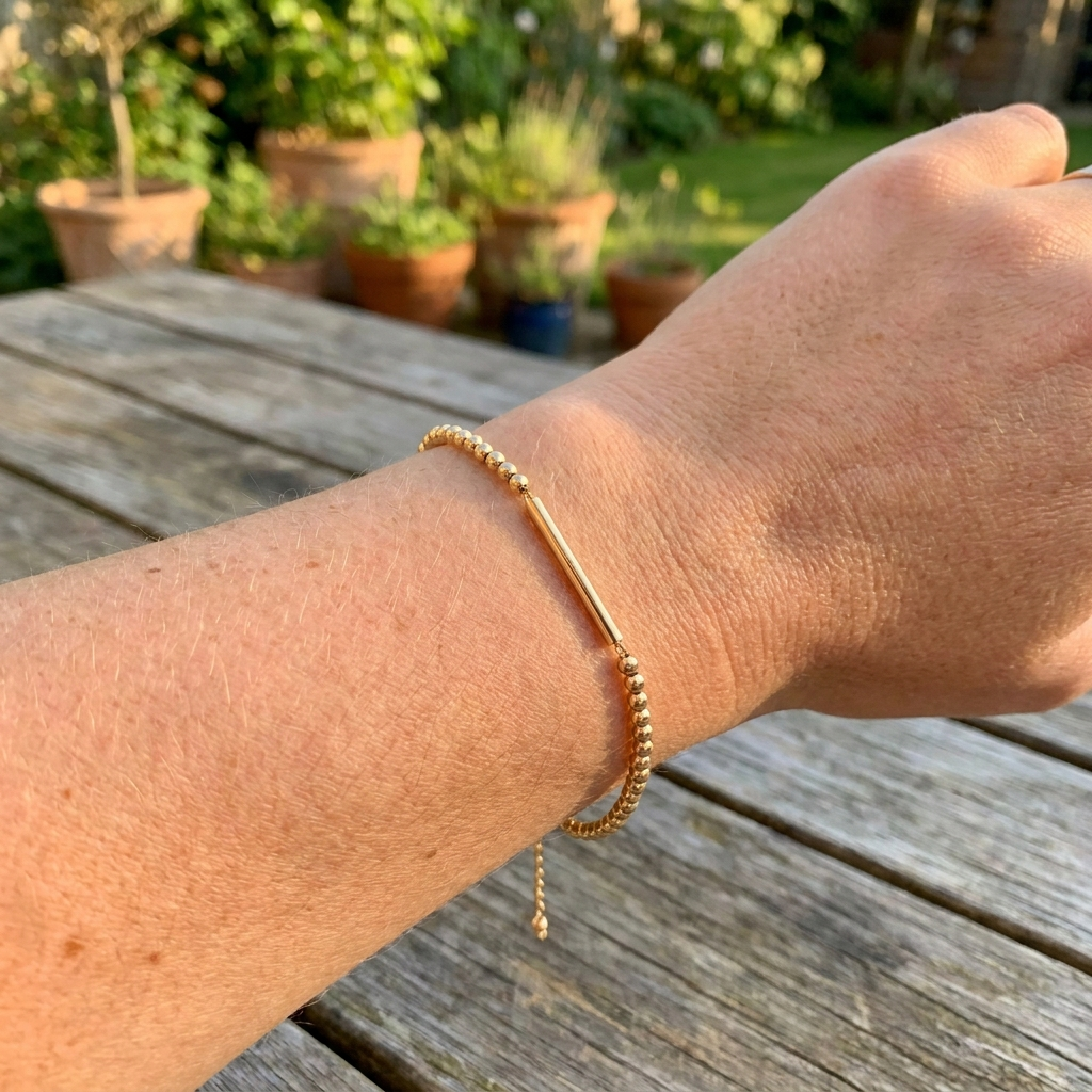 Bracelet Code Morse doré porté au poignet